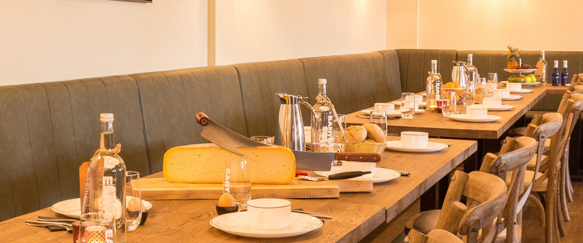 Lange ontbijtbanken plaats genoeg om met z'n allen aan te ontbijten